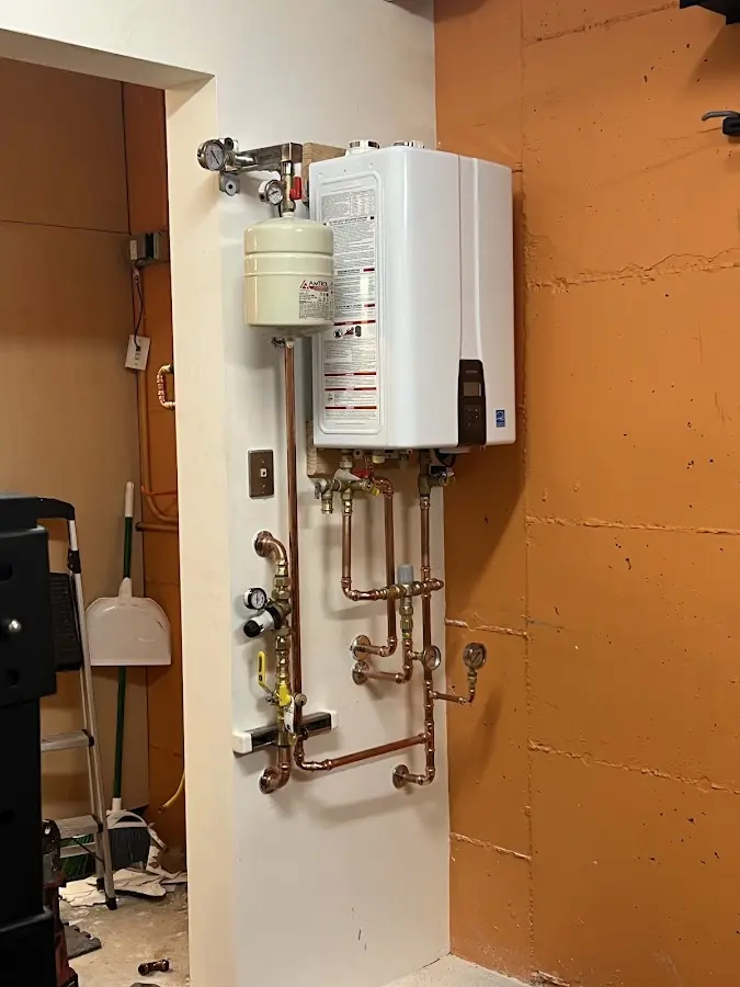 Plumbing technician inspecting water heater connections in Park City
